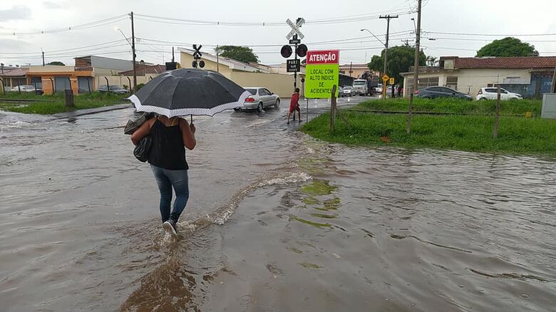 Mulher se arrisca a passar pelo alagamento - Crédito: Nelsinho Pereira