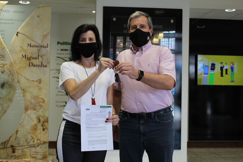 Ganhadora recebe chaves do carro e escritura do apartamento da campanha Natal Premiado ACISC -