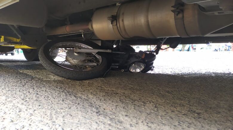 Moto foi parar embaixo do ônibus após a colisão lateral - Crédito: Maycon Maximino