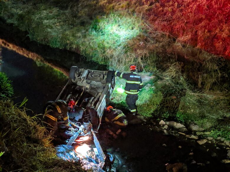 Membros do Corpo de Bombeiros durante o socorro ao motorista do veículo que caiu no córrego - Crédito: Maycon Maximino
