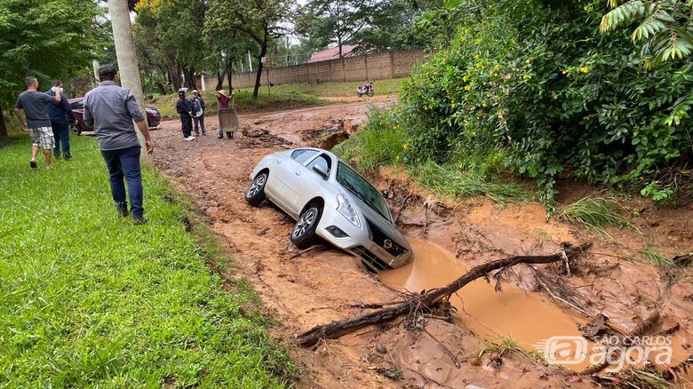 Carro caiu em valeta durante a forte chuva que atingiu o bairro nesta quinta-feira - Crédito: divulgação