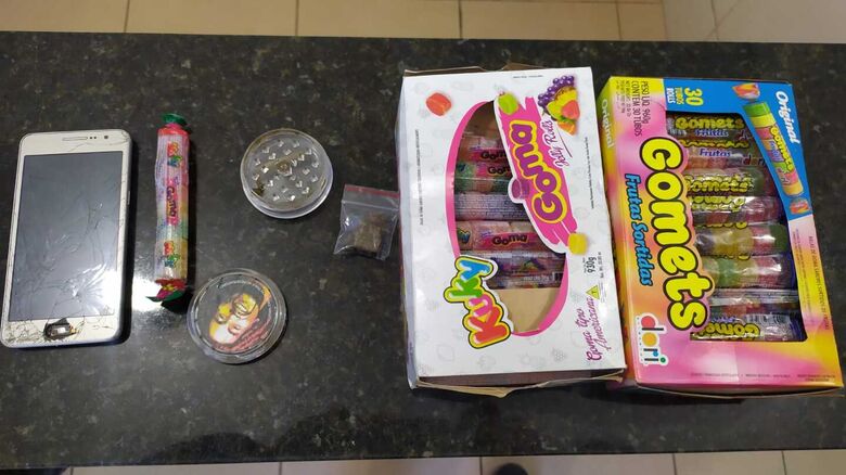 Os doces, celular, dichavador e maconha que estava com o adolescente - Crédito: Maycon Maximino