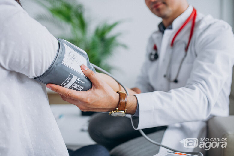 Médico mede pressão arterial em jovem - Crédito: senivpetro/Freepik