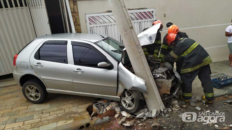 Impacto violento abalou a estrutura de um poste e danificou o portão de uma garagem: casal ficou ferido - Crédito: Maycon Maximino