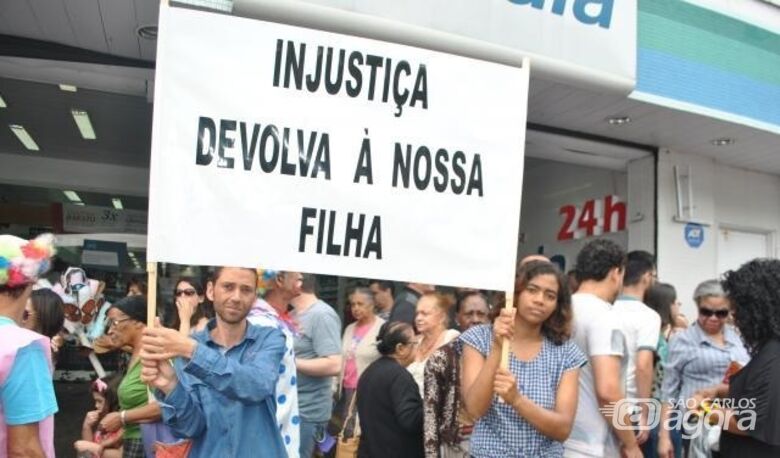 Casal segurando o cartaz durante desfile de aniversário de São Carlos em 2017 - Crédito: arquivo/Folha São Carlos e região