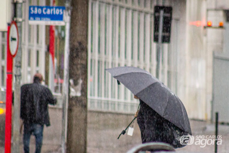 Mulher caminha com guarda chuva no Centro de Sâo Carlos - Crédito: SCA