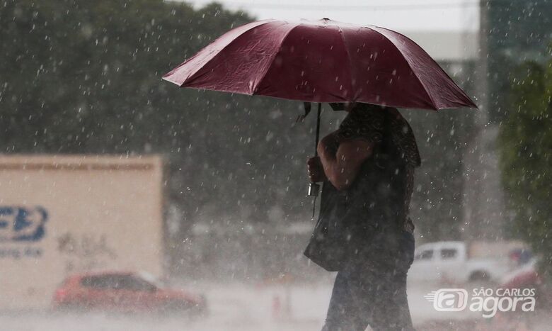 Mulher usa guarda chuva para se proteger - Crédito: Foto: Marcello Casal Jr/Agência Brasil