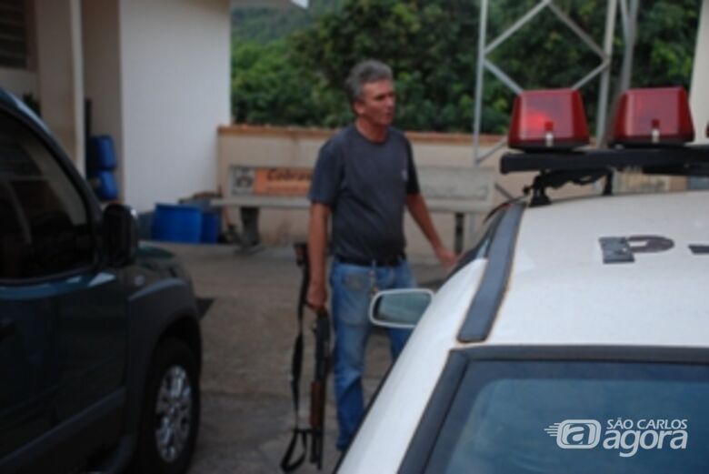 Policial que participou da ação carrega arma na delegacia de Ribeirão Bonito - 