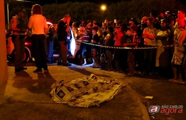 Populares observam o corpo da vítima caido na calçada. (foto: Marcio David) -