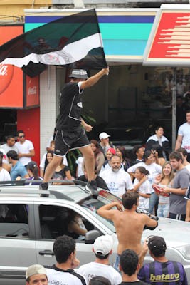 Torcedor sobe no teto de carro para comemorar a conquista. (foto Mauricio Duch). -