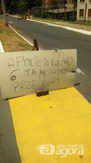Placa colocada na entrada do CDHU alerta para a presença da PM no local - Crédito: Divulgação