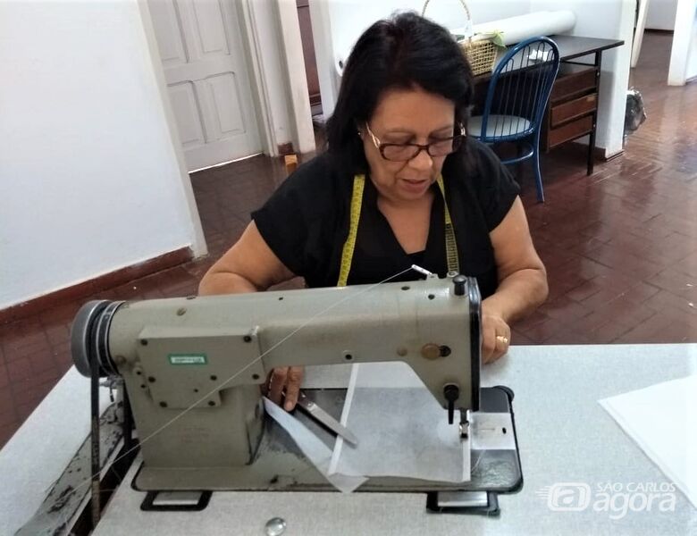 A voluntária Lucia Chaves costurando os equipamentos de proteção individual - Crédito: Divulgação