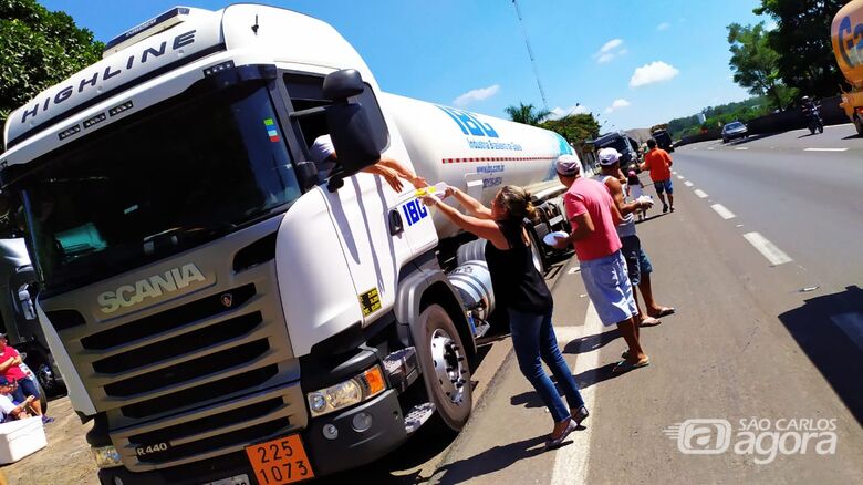 Caminhoneiro recebe alimento em ação solidária: gratidão por São Carlos - Crédito: Maycon Maximino