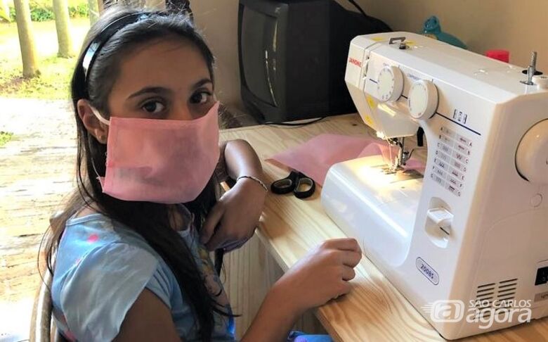 Liz Maria de Lorenzo Paschoal, de 10 anos, ajudando a fazer máscaras - Crédito: Divulgação